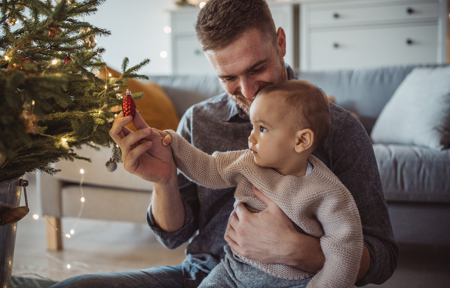 Baby and dad with christmas decorations and christmas tree