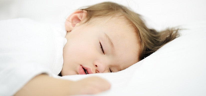 A parent taking the temperature of a feverish baby