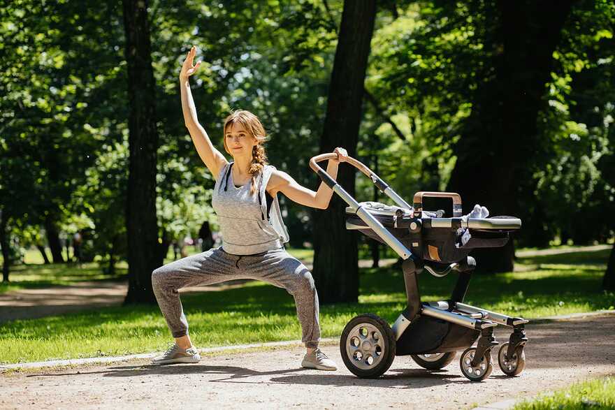 A parent doing a squat exercise with the baby nearby