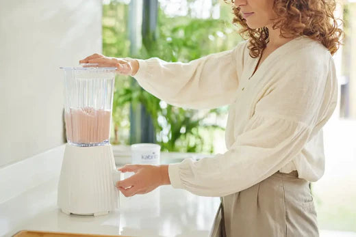 Mother makes a smoothie with a blender