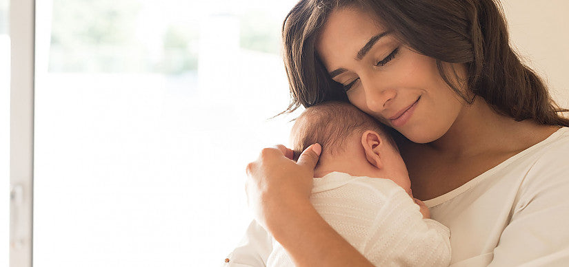 A parent holding a baby during a feed